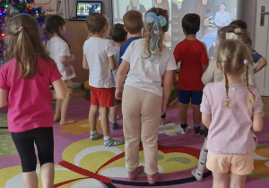 Dzieci stoją przed tablicą.