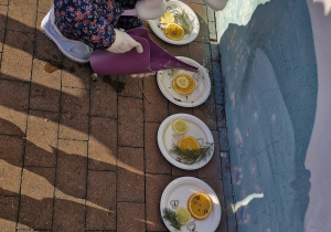 Dziewczynka zalewa wodą przygotowane kompozycje.