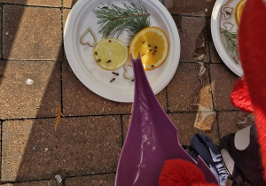 Dziecko zalewa wodą przygotowaną kompozycję.