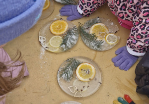 Dzieci oglądają powstałe lodowe mandale.