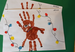Praca plastyczna wykonana przez dzieci – renifer z odbitych rąk.