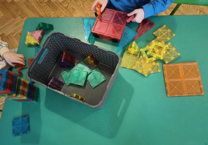 Dzieci konstruują z klocków magnetycznych.