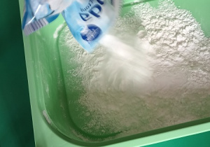 Dziecko wsypuje do pojemnika sodę.