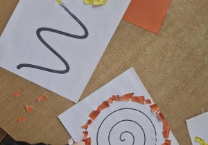 Dzieci wyklejają różne wzory kolorowym papierem.