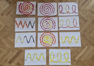 Gotowe prace dzieci - szlaczki wyklejone kawałkami kolorowego papieru.