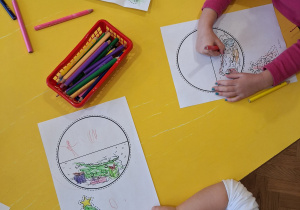 Dzieci kolorują kredkami bombki.