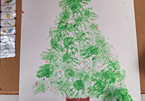 Wspólna praca plastyczna, choinka z odbitych rąk dzieci.