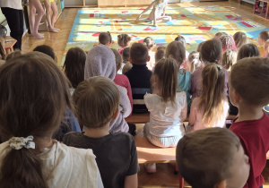 Dzieci oglądają występ gimnastyki artystycznej.