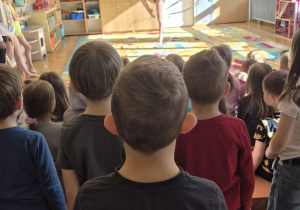 Dzieci patrzą na dziewczynkę tańczącą ze wstążką.