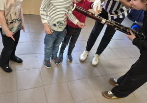 Dzieci stoją przy instrumencie.