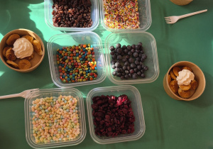 Na stole miseczki z pancakes oraz dodatki.