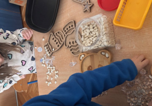 Dzieci tworzą wysypywanki zimowe, rękawiczki, choinki.