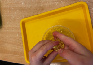 Dziecko ściska w dłoniach kawałki galaretki.