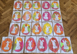 Prace dzieci - kolorowe pisanki z białym zajączkiem na środku.