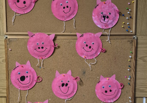 Na tablicy wywieszone prace dzieci - świnki wykonane z papierowych talerzyków.