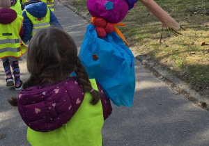 Dziewczynka trzyma w rękach dużą marzannę.