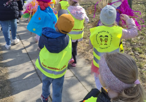 Dzieci wznoszą marzanny do góry podczas spaceru.