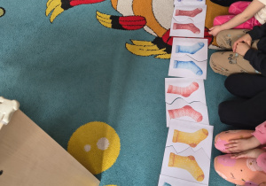 Dzieci dobierają skarpetki w pary - dopasowują do siebie ilustracje.