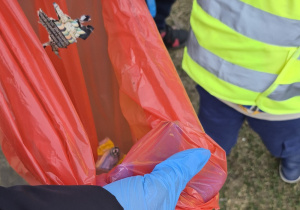 Dziecko wrzuca śmieci do worka.