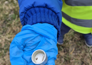 Dziecko pokazuje śmieci, które znalazło.