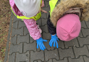 Dziewczynki pokazują rączki w rękawiczkach jednorazowych.
