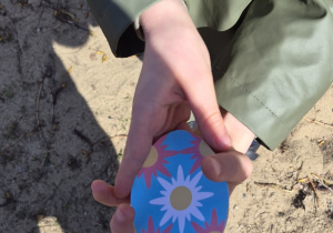 Dziecko pokazuje znalezione papierowe jajko.