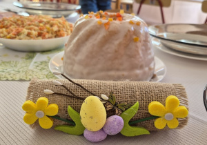 Na stoliku stroik wielkanocny i babka.