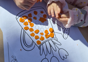 Dzieci wykonują zadania od zajączka - wyklejają konewkę plasteliną.