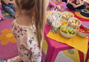 Dziewczynka patrzy na owoce.