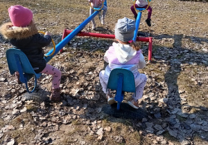 Dzieci bujają się na huśtawce.