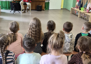 Dzieci obserwują mężczyznę grającego na akordeonie.