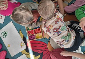 Dzieci wybierają dary Froebla aby ułożyć oznaki wiosny.