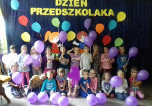 Dzieci trzymają fioletowe balony