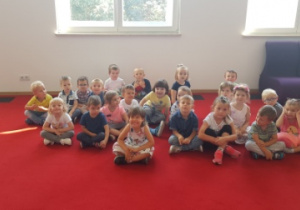 - Dzieci siedzą na podłodze w Pałacu Młodzieży i czekają na przedstawienie