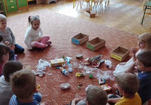 Dzieci szykują się do segregacji śmieci.