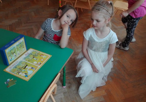 Dziewczynki prezentują ułożone puzzle – dobre i złe zachowanie w lesie.