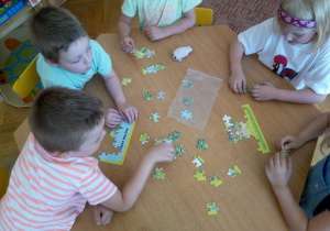 Dzieci układają puzzle – dobre i złe zachowania w lesie.