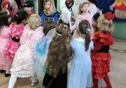 W kole stoją dziewczynki przebrane na motylki, księżniczki, biedronki.