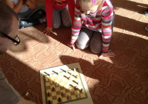 Dzieci grają w planszową grę na podłodze