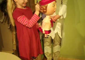 Dziewczynka trzyma lalkę Czerwonego Kapturka