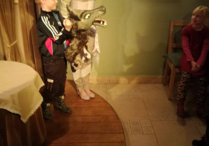 Chłopiec trzyma lalkę wilka