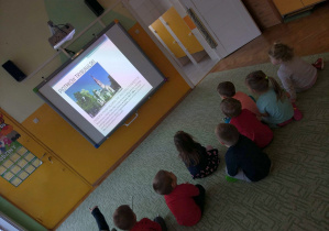 - Dzieci siedzą na dywanie i oglądają film o Piotrkowie Trybunalskim