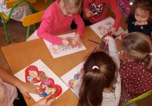 Dziewczynki rysują w sercach uśmiechnięte dzieci