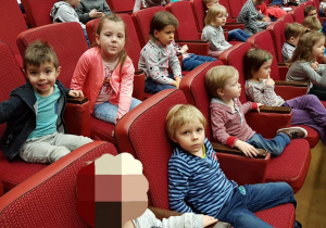 - Dzieci siedzą w fotelach w teatrze i czekają na przedstawienie