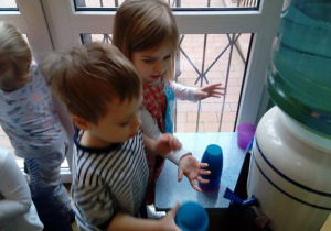 - Dzieci nalewają wodę do kubków
