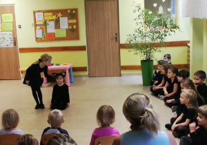 dziewczynki prezentują wiersz J. Tuwima „ Kotek „ przed małymi dziećmi