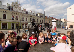 Dzieci pozują przy pomniku Trzech Fabrykantów na ulicy Piotrkowskiej.