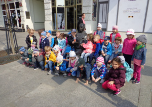 Dzieci pozują przy pomniku Fotel Jaracza znajdującego się na ulicy Piotrkowskiej.