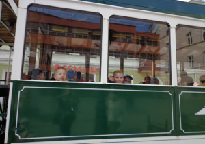 Dzieci machają z trambusu.