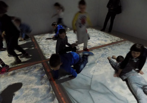 Dzieci bawią się w Sali z oświetloną podłogą.